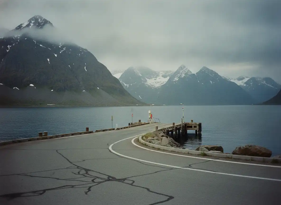 Liten ferjekai i en nordnorsk havn med oppstillingsfelt og fjell bak